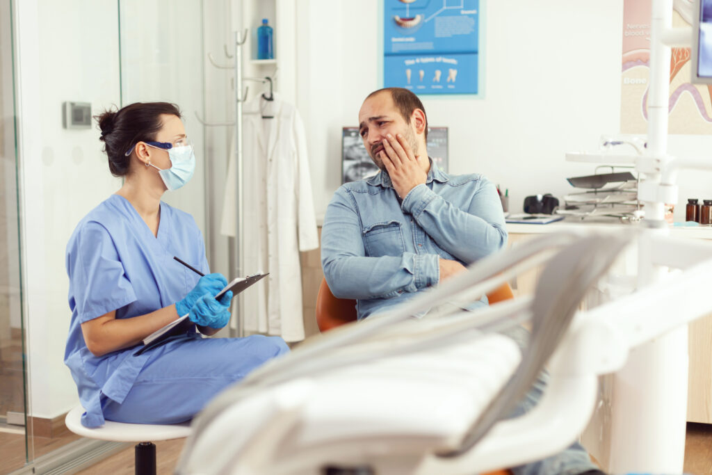 Dental assistant writing stomatology treatment on clipboard in dental clinic